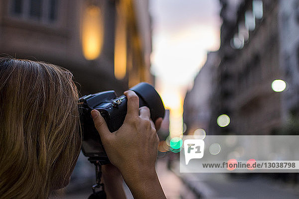Beschnittenes Bild einer Frau  die in der Stadt mit einer Digitalkamera fotografiert