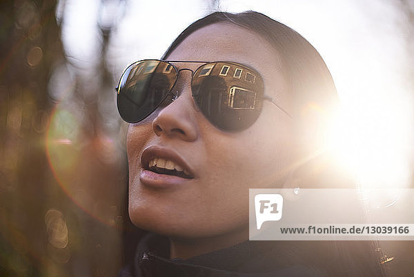 Nahaufnahme einer selbstbewussten Frau mit Sonnenbrille an einem sonnigen Tag in der Stadt