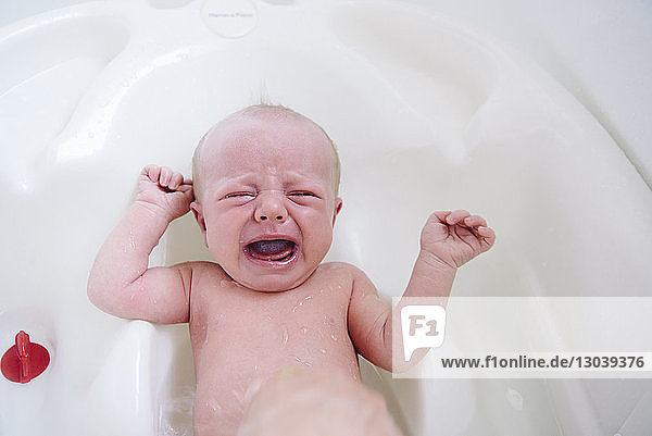 Hochwinkelaufnahme eines weinenden Mädchens in der Badewanne