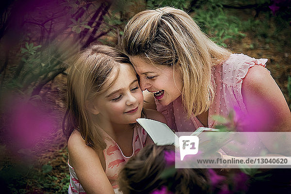 Hochwinkelansicht einer glücklichen Mutter und Tochter beim Lesen eines Buches