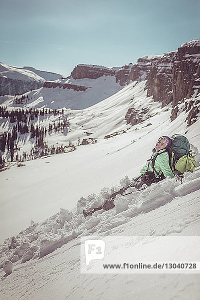 Glückliche Frau rutscht auf schneebedecktem Berg im Grand-Teton-Nationalpark