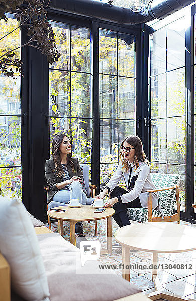 Businesswomen discussing while sitting in cafe