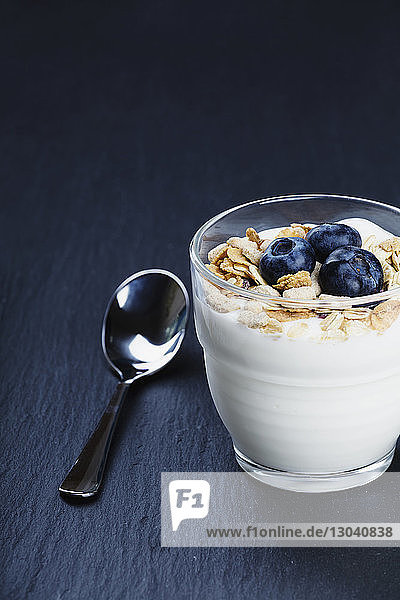 Joghurt mit Frühstücksflocken und Blaubeeren auf dem Tisch serviert