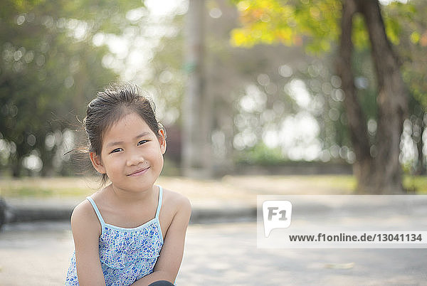 Porträt eines lächelnden Mädchens im Park sitzend