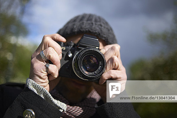 Nahaufnahme eines Mannes  der mit einer DSLR-Kamera in Paris fotografiert