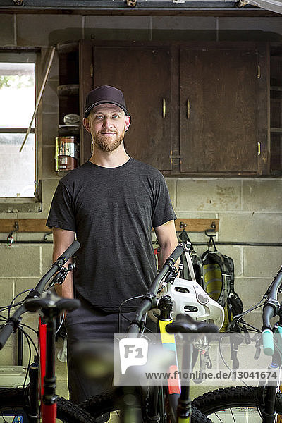 Porträt eines selbstbewussten Mechanikers  der im Fahrradladen steht