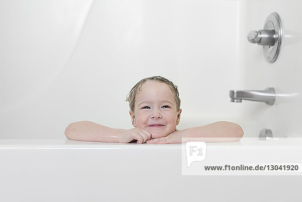Smiling girl sitting in bathtub