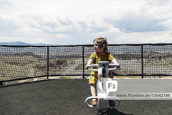 Carefree girl playing on rocking horse at playground