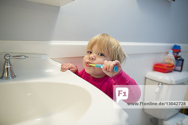 Porträt eines Mädchens beim Zähneputzen am häuslichen Waschbecken