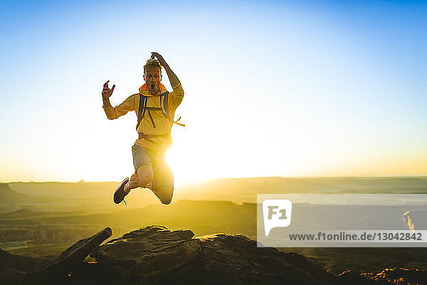 Aufgeregter Wanderer springt auf Berg im Canyonlands-Nationalpark