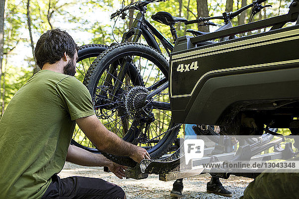 Freunde stellen Mountainbikes auf Geländewagen im Wald ein