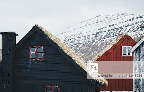 Häuser auf Feld gegen schneebedeckten Berg
