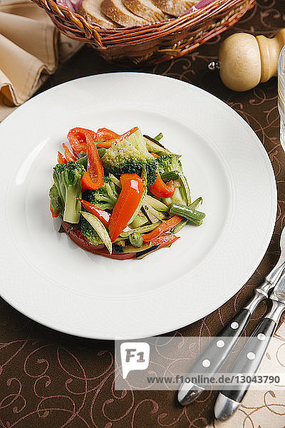 Hochwinkelansicht eines Salats  der in einem Teller auf dem Tisch serviert wird