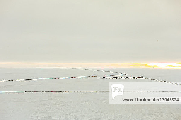 Ansicht eines schneebedeckten Feldes einer metallischen Pipeline gegen den Himmel