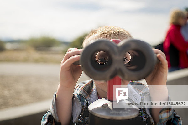 Portrait of boy looking through binoculars