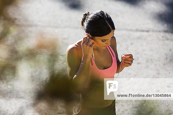 High angle view of athlete listening music on footpath