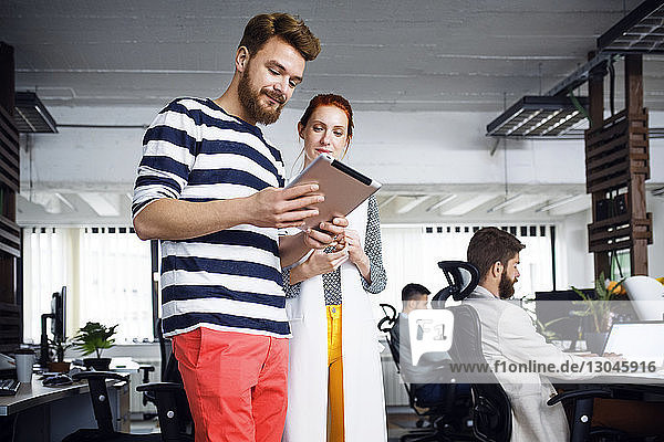 Geschäftsleute  die einen Tablet-Computer im Kreativbüro benutzen