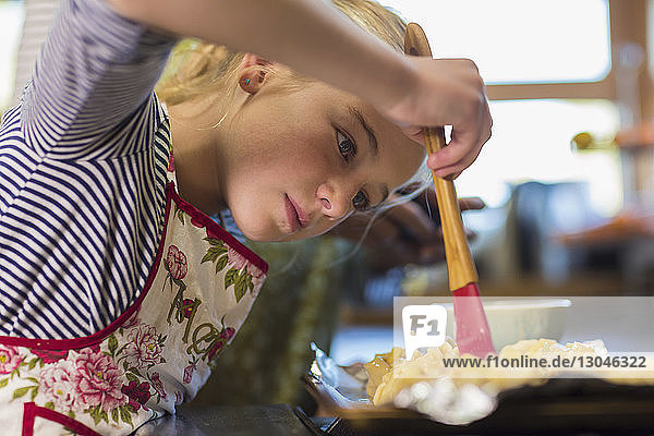 Girl applying oil on food with brush