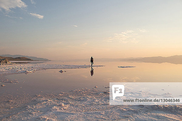 Mittelstrecke einer Frau  die bei Sonnenuntergang am Großen Salzsee steht