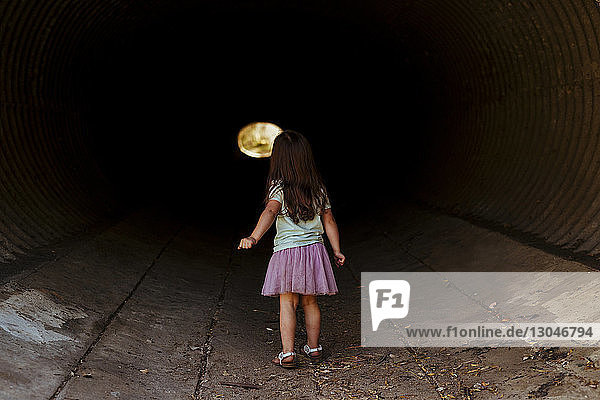 Rückansicht eines im Tunnel gehenden Mädchens