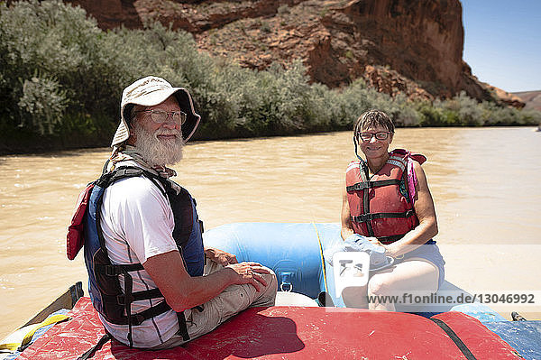 Portrait of senior man and woman sitting in inflatable raft on San Juan River