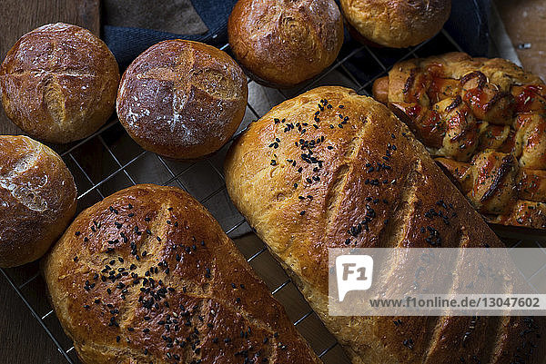 Draufsicht auf frisch gebackene Brote auf einem Kühlgestell zu Hause
