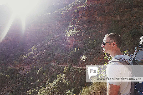 Side view of man standing by mountain at grand canyon