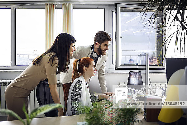 Business people using computer in creative office