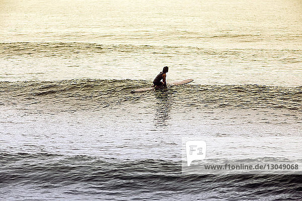 Hochwinkelaufnahme eines Mannes beim Surfen im Meer