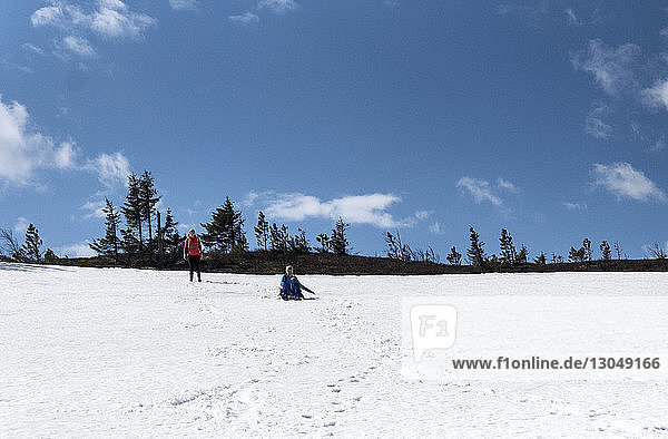 Wanderer spielen auf schneebedecktem Feld gegen den Himmel