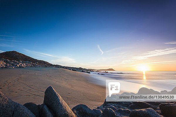 Szenische Ansicht des Strandes vor blauem Himmel bei Sonnenuntergang