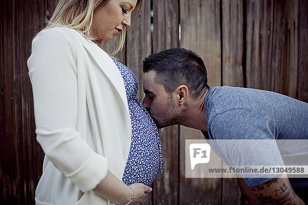 Man kissing on pregnant woman's stomach