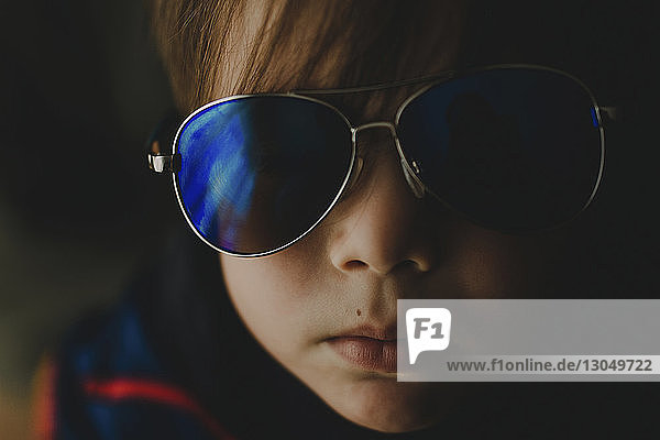 Close-up portrait of cute baby boy in sunglasses at home