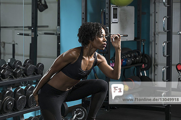 Determined woman listening music while exercising in gym