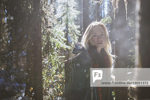 Porträt einer Frau  die im Winter im Wald wandert
