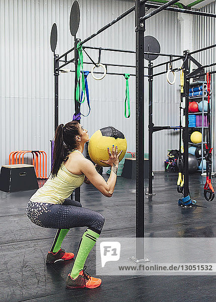 Athlete exercising with medicine ball in gym