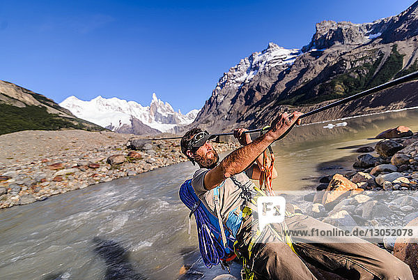 Rock climber sliding on rope over river  El Chaltén  south Patagonia  Argentina