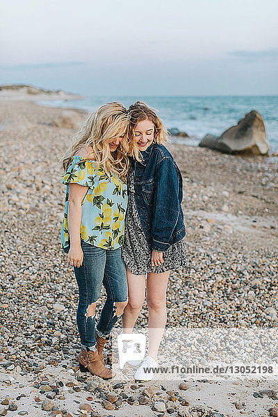 Zwei junge Frauen umarmen sich am Strand, Menemsha, Martha's Vineyard, Massachusetts, USA