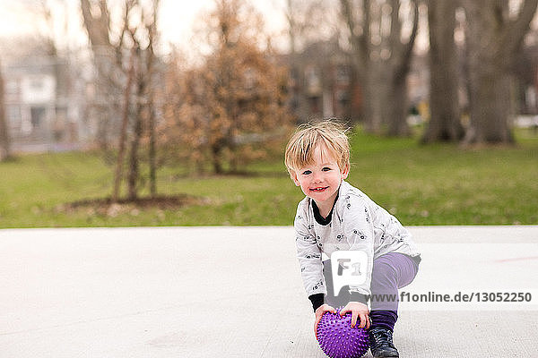 Junge spielt Ball im Park