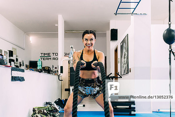 Frau benutzt Seilpeitschen beim Training im Fitnessstudio