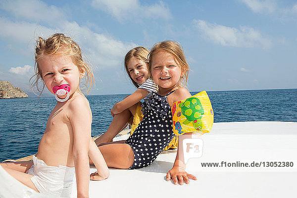 Three cute girls sitting on boat  portrait  Castellammare del Golfo  Sicily  Italy