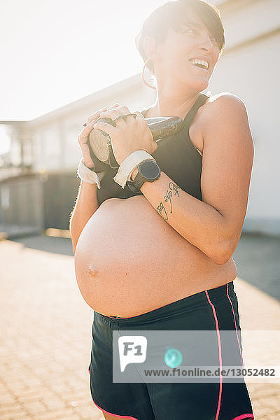 Schwangere Frau benutzt Kettlebell im Freien