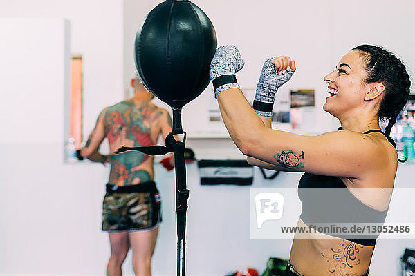 Woman using punch bag in gym
