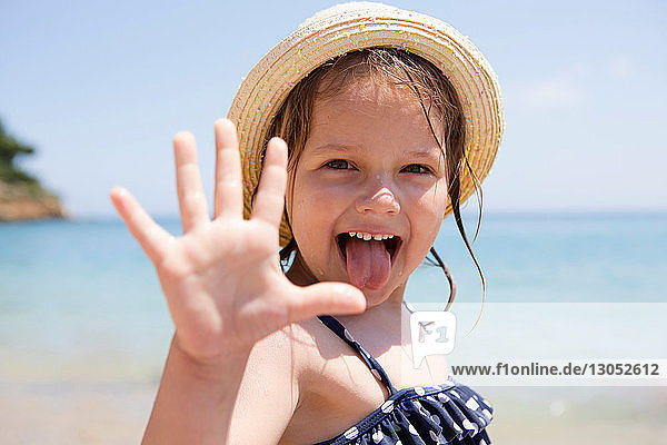 Girl in sunhat sticking out her tongue  portrait  Scopello  Sicily  Italy