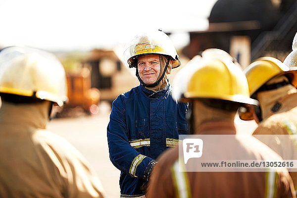 Firemen training  firemen listening to supervisor at training facility  over shoulder view
