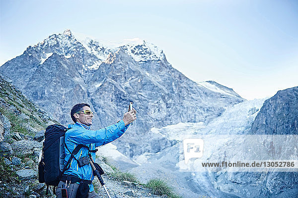 Hiker taking photograph  Mont Cervin  Matterhorn  Valais  Switzerland