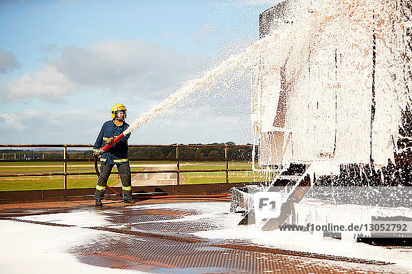 Firemen training  fireman spraying firefighting foam at training facility