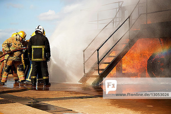Firemen training  firemen spraying water at training facility stairway