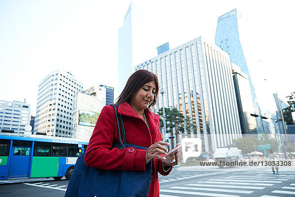 Geschäftsfrau mit Smartphone in der Stadt  Seoul  Südkorea