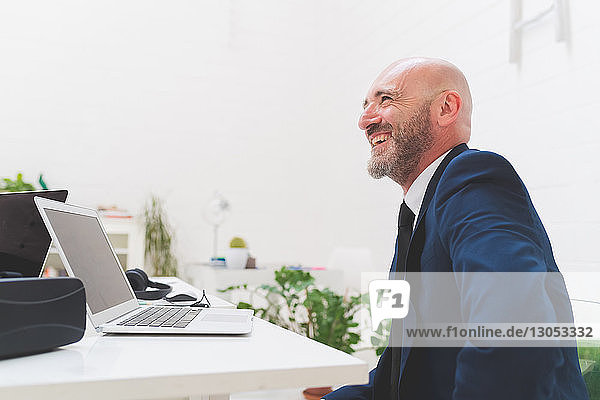 Businessman laughing at office desk